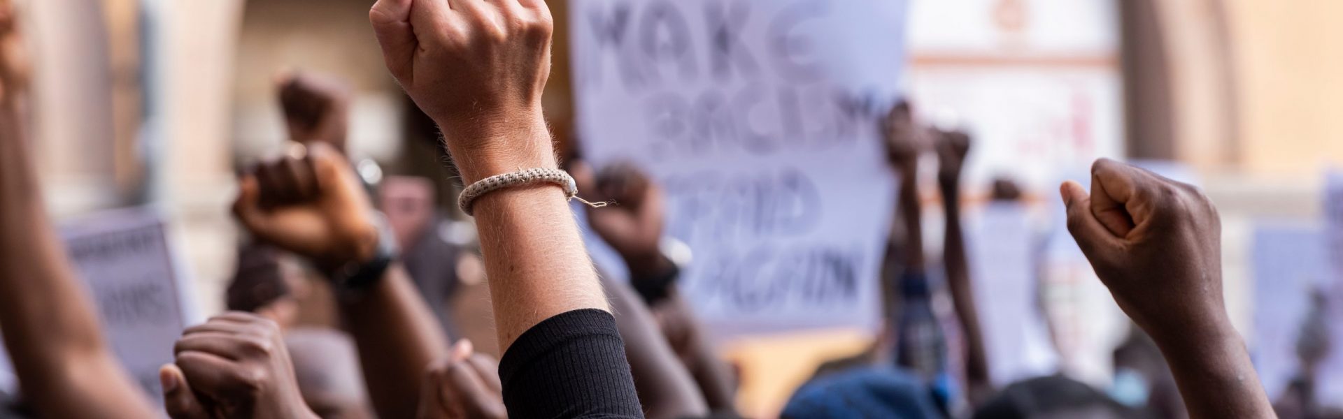 A crowd of protesters with their hands extended in the air.